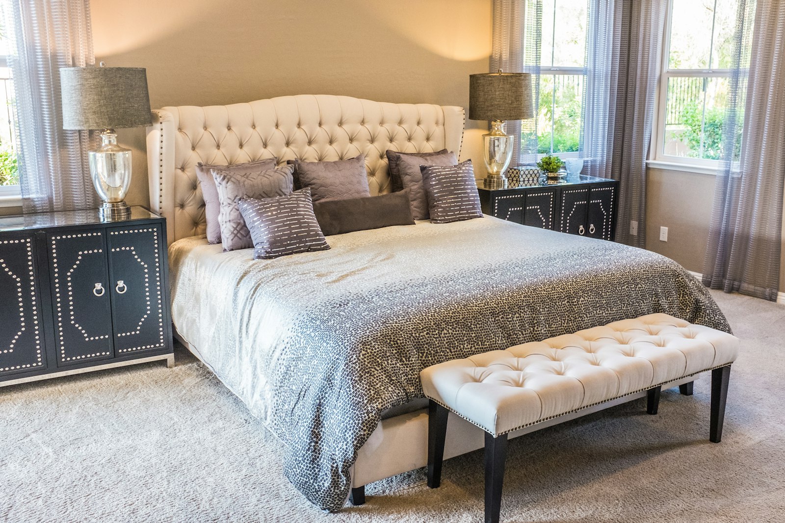 A bedroom dressed in linen with a simple upholstered headboard.