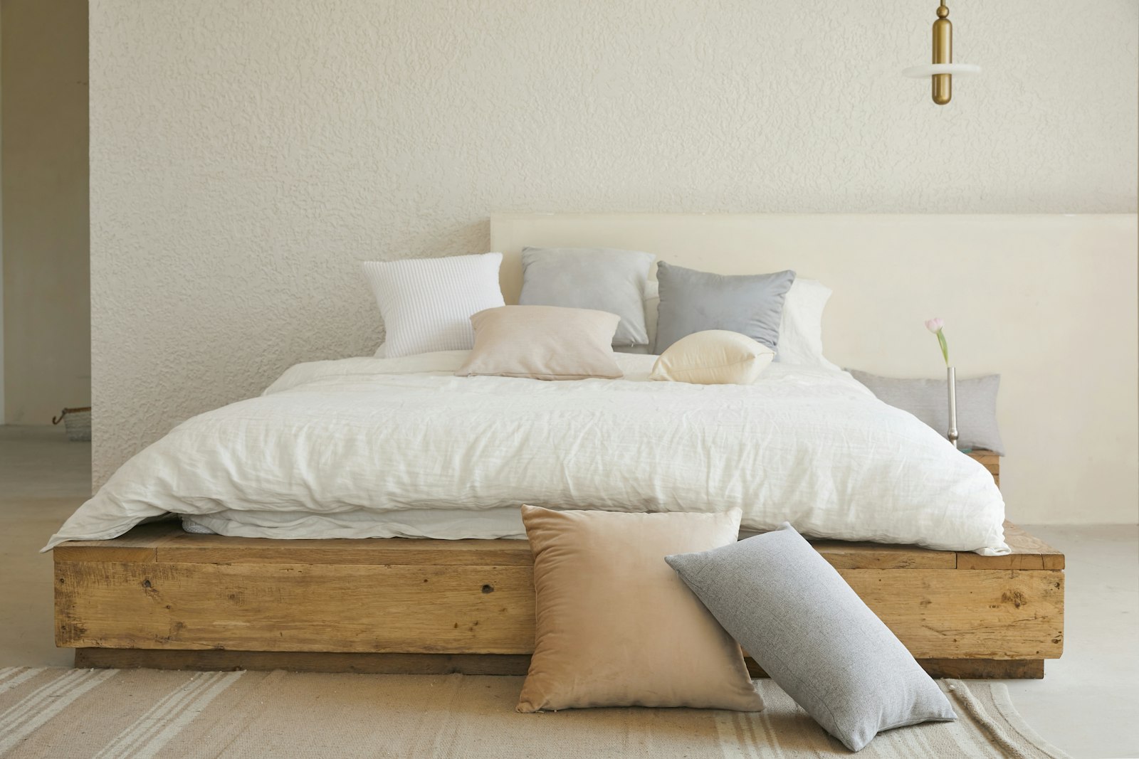 A bedroom with a soft upholstered headboard and warm light.